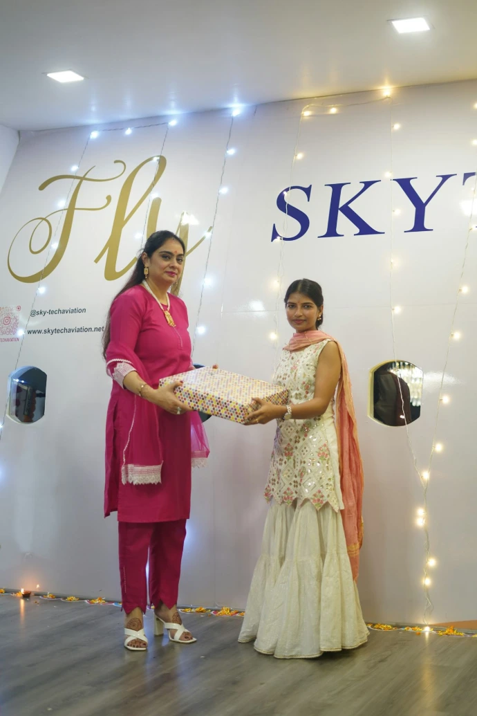 Two women receiving a gift in a decorated room